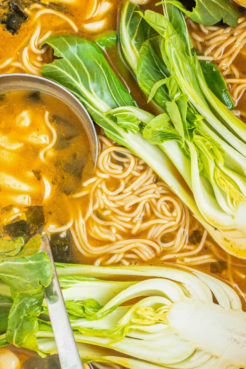 close up of easy ramen with a stainless steel ladle.