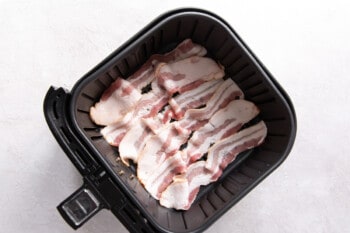 slices of bacon in an air fryer before cooking