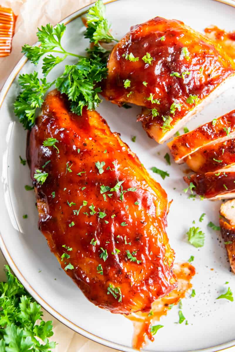 2 bbq chicken breasts on a white plate