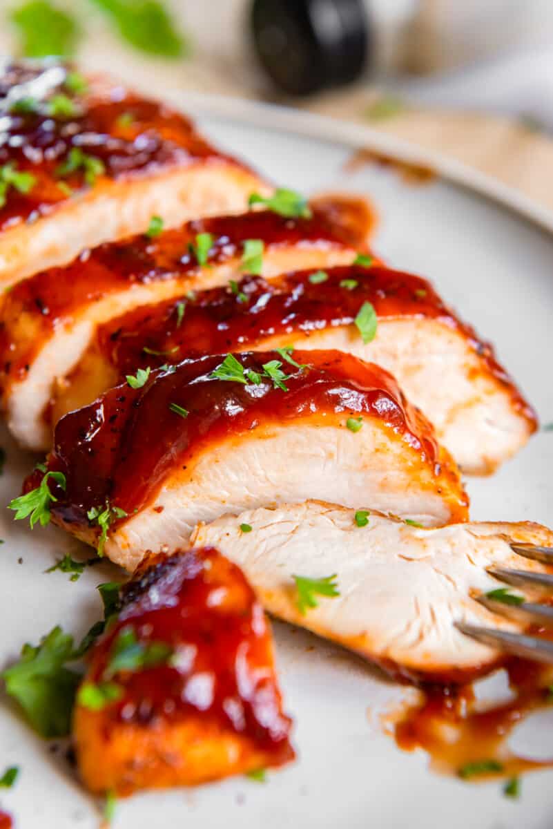 sliced bbq chicken breast on a plate with a fork