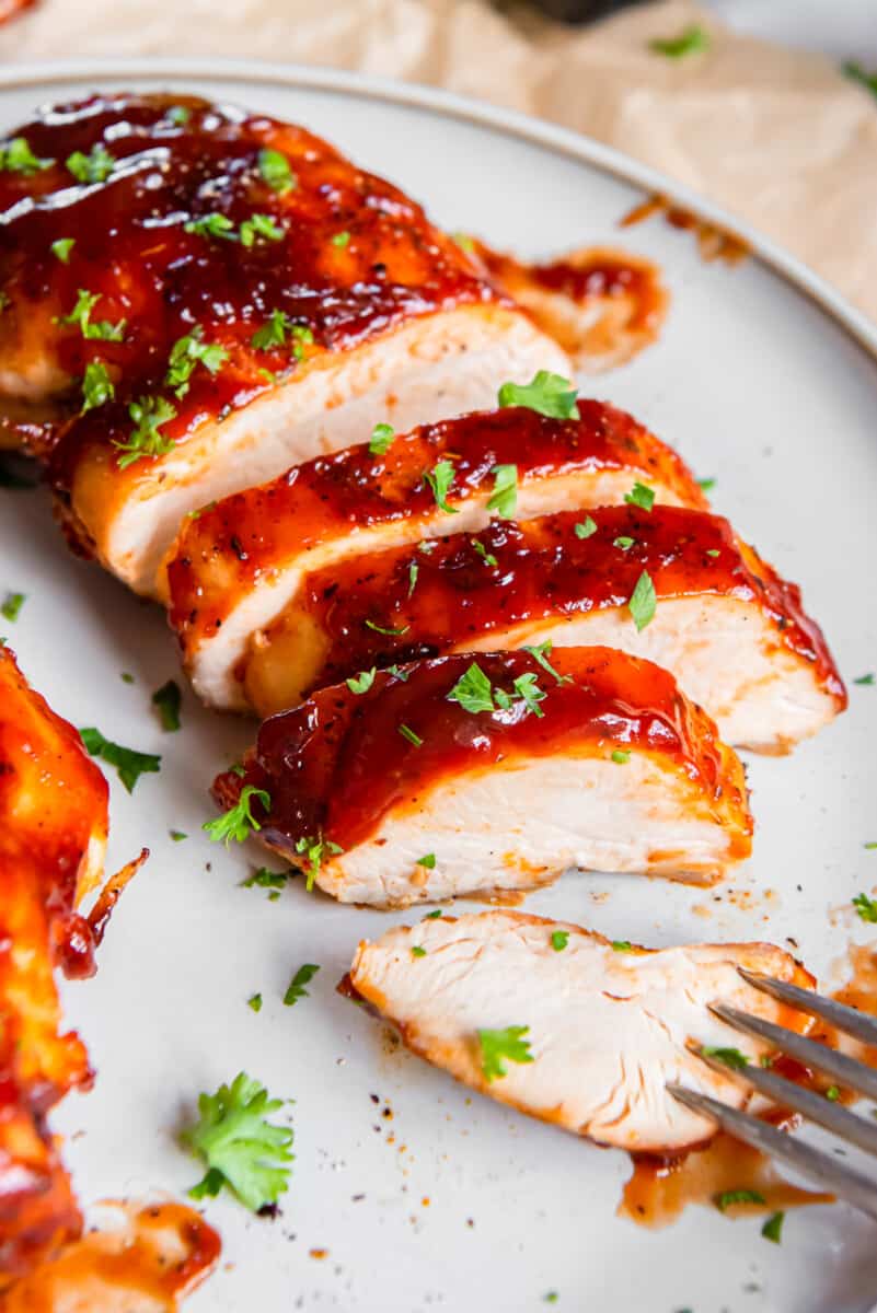 sliced bbq chicken breast on a plate with a fork