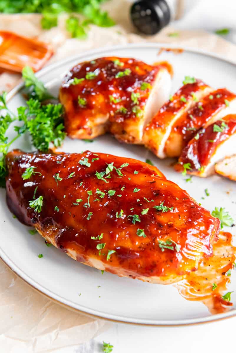 2 bbq chicken breasts on a white plate