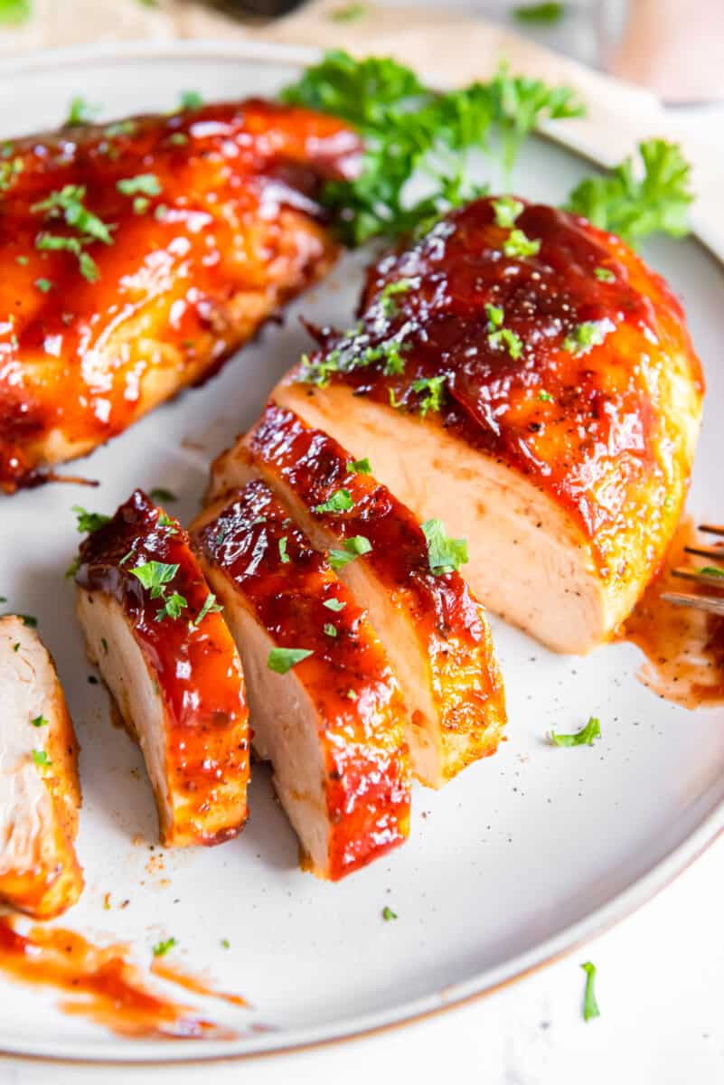 sliced bbq chicken breast on a white plate