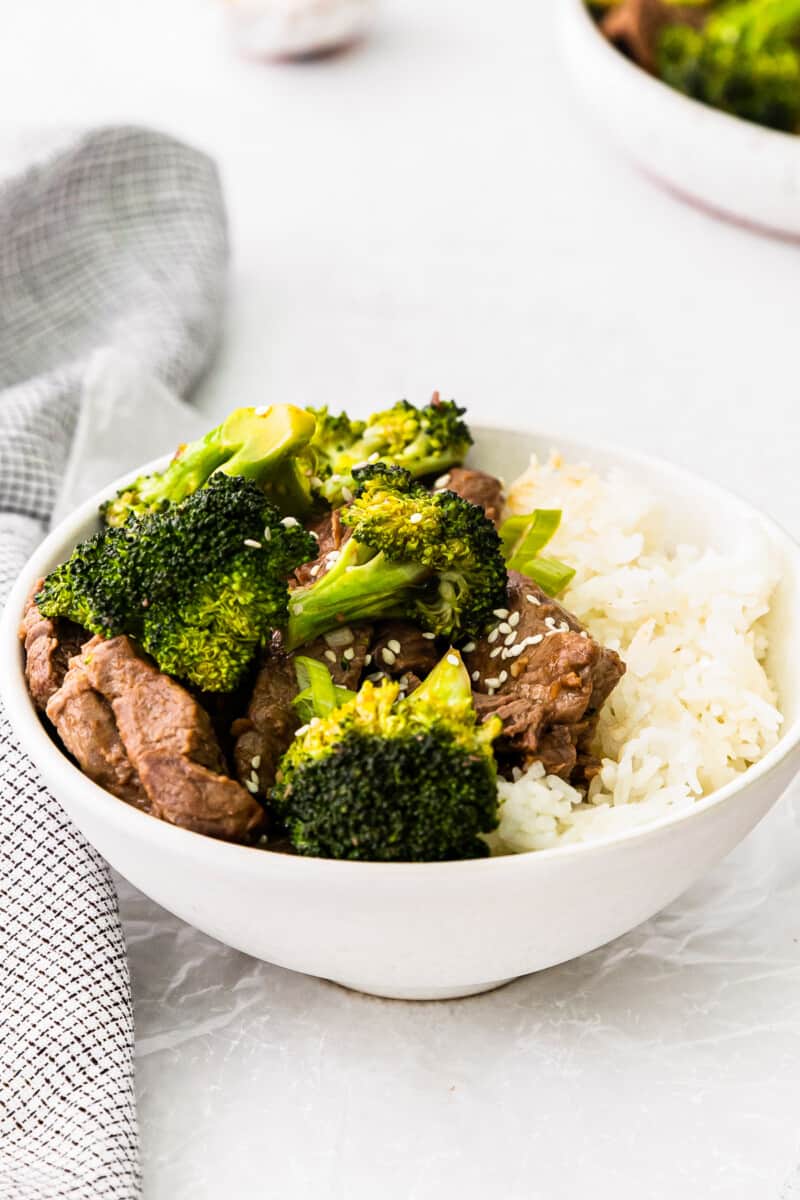 beef and broccoli with rice in a white bowl