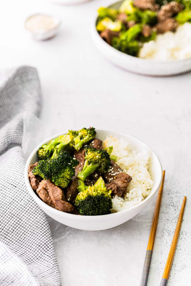beef and broccoli with rice in a white bowl