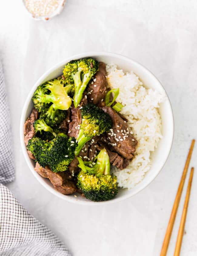 overhead image of beef and broccoli with rice in a white bowl
