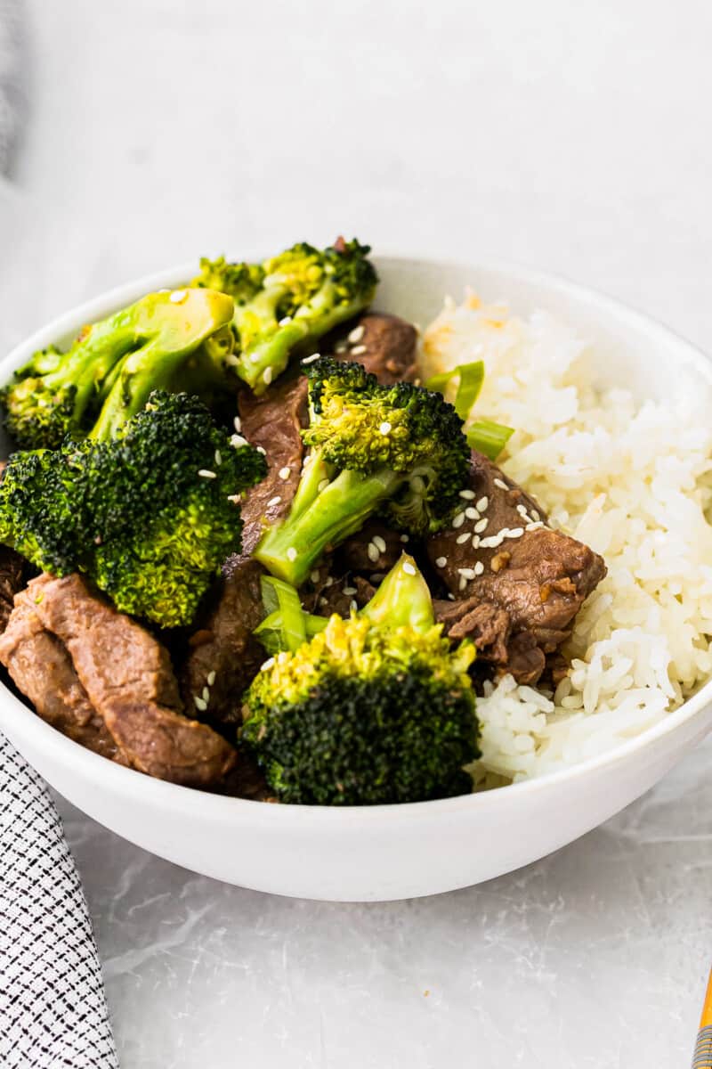 beef and broccoli with rice in a white bowl