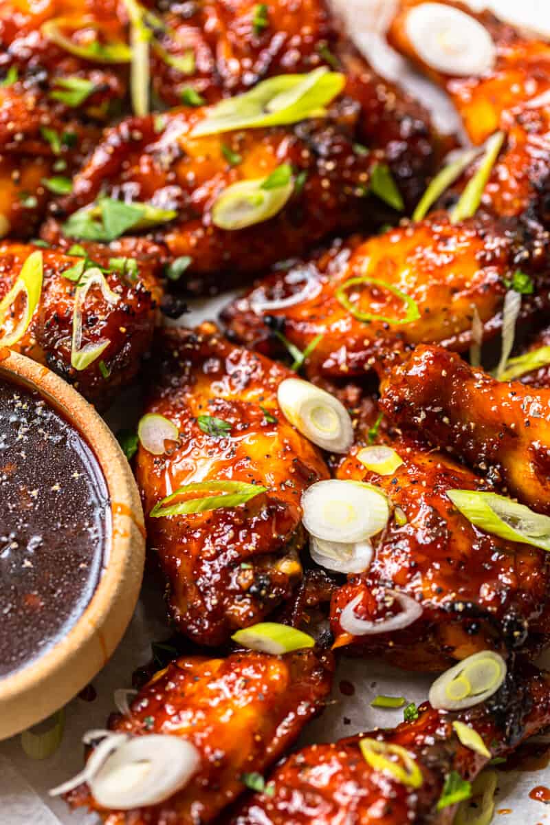 baked korean hot wings on a serving platter with sauce in a bowl