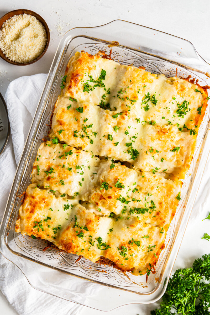 overhead image of chicken alfredo lasagna roll ups in a casserole dish