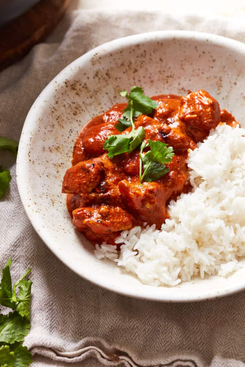 white bowl with chicken tikka masala and rice