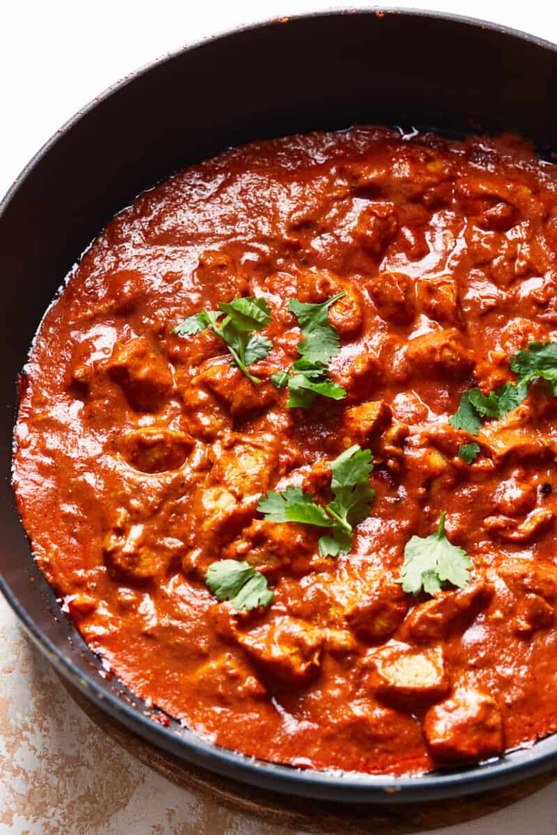 chicken tikka masala in skillet garnished with cilantro