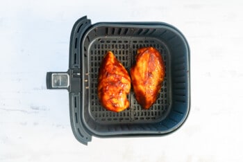 2 bbq chicken breasts after cooking in air fryer basket