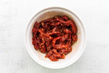 marinated steak slices in a white bowl