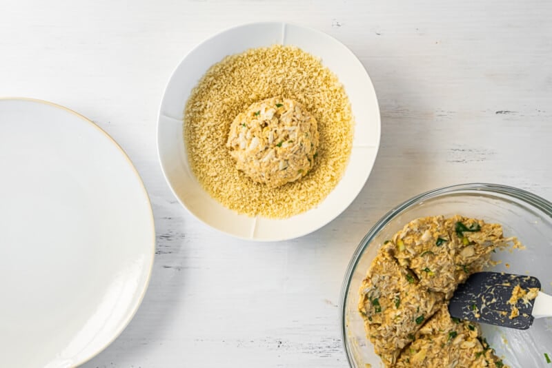 crab cake in a bowl of bread crumbs