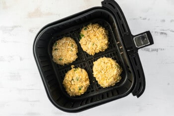 4 crab cakes in an air fryer before cooking