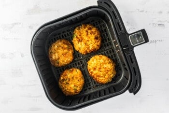 4 crab cakes in an air fryer after cooking