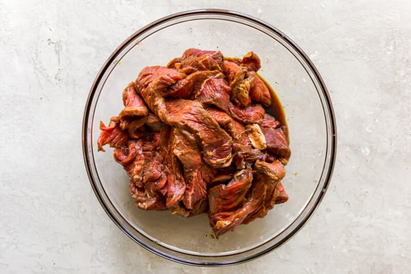 beef slices with marinade in a glass bowl