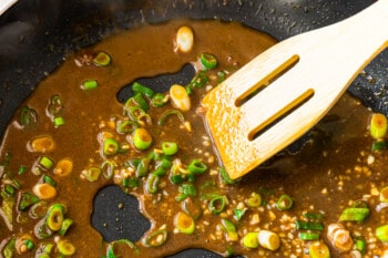 sauce in wok with a wood spoon