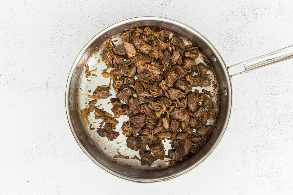 Shredded beef in a skillet.