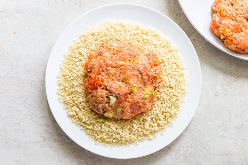 salmon burger patty on a plate with breadcrumbs