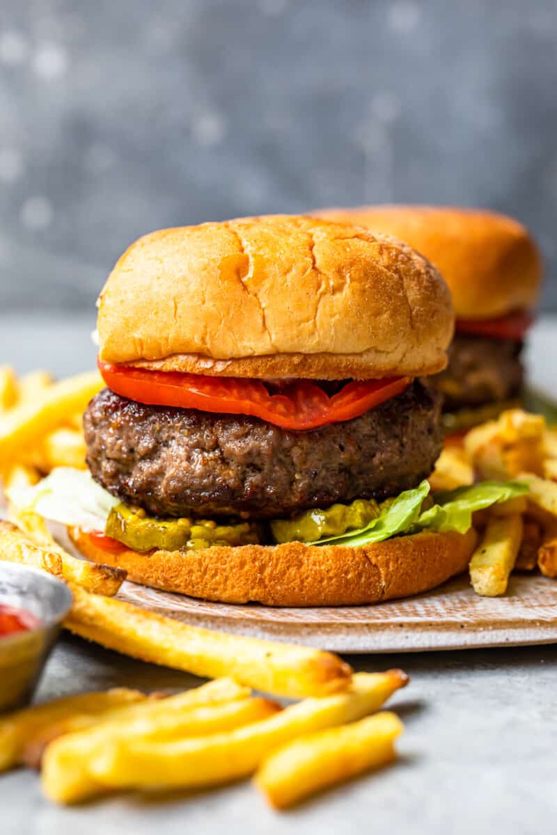 hamburger on a bun topped with pickles, lettuce, and tomato