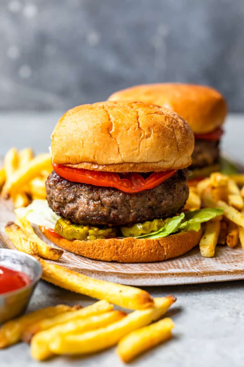 hamburger on a bun topped with pickles, lettuce, and tomato