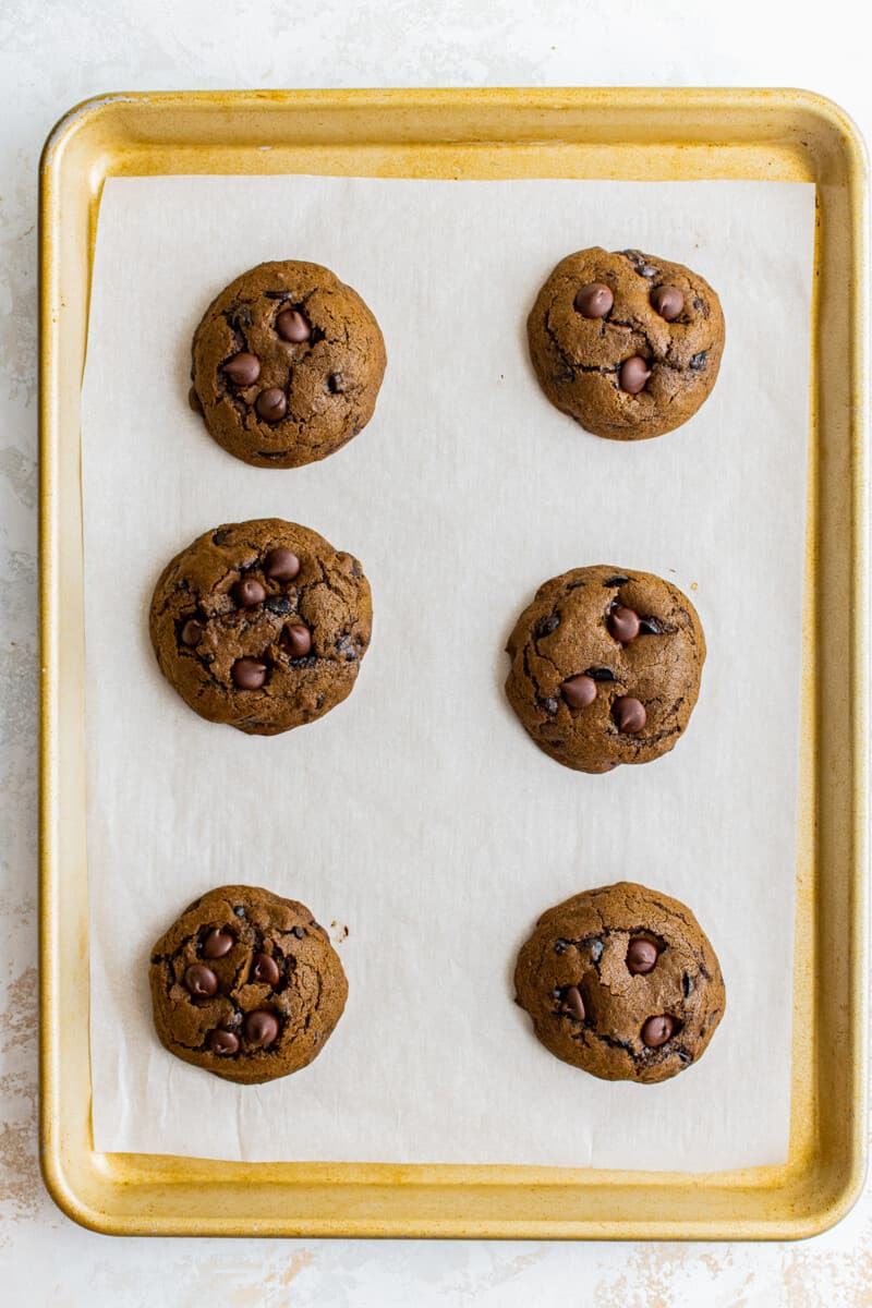 6 mocha cookies after baking on a baking sheet lined with parchment paper