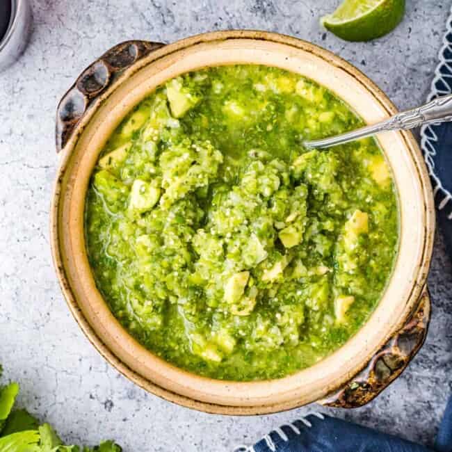 tomatillo avocado salsa in a bowl with a spoon