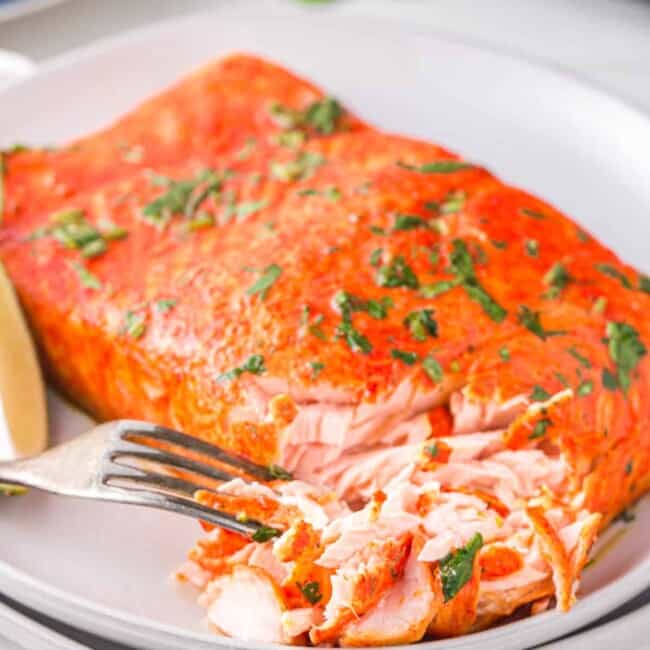 cilantro lime salmon on a white plate with a fork