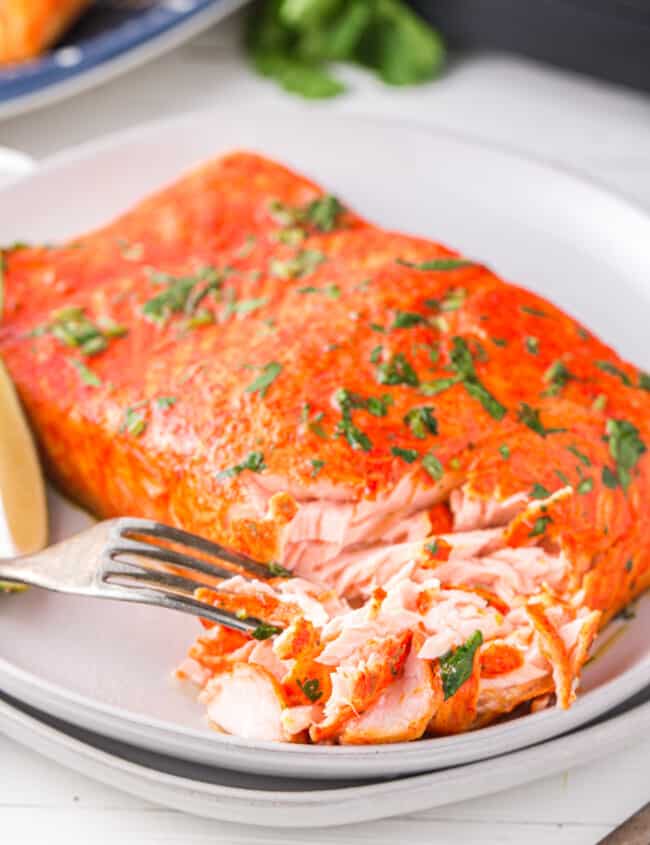 cilantro lime salmon on a white plate with a fork