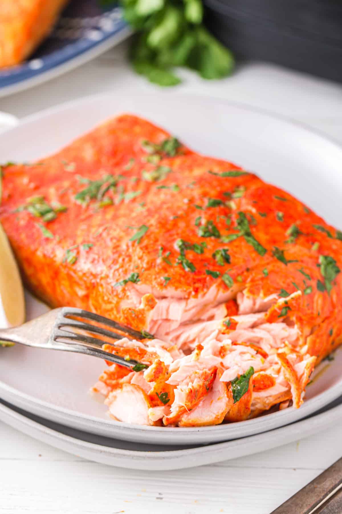 cilantro lime salmon on a white plate with a fork