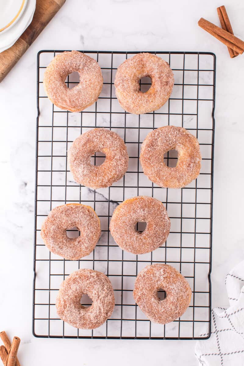 overhead image of 8 cinnamon sugar donuts on a cooling rack