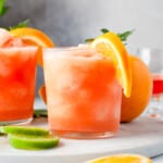 frozen Aperol margaritas in glasses with orange slice and mint garnishes