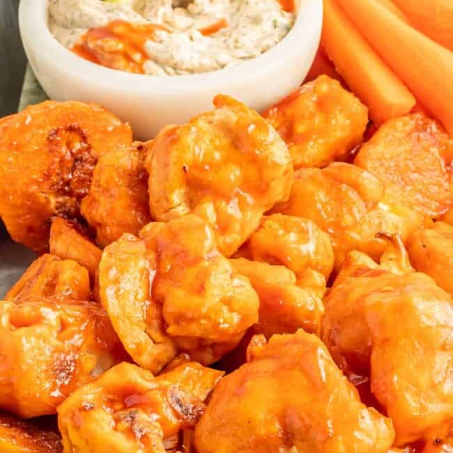 buffalo cauliflower wings on a serving tray with buffalo ranch dressing in a white bowl