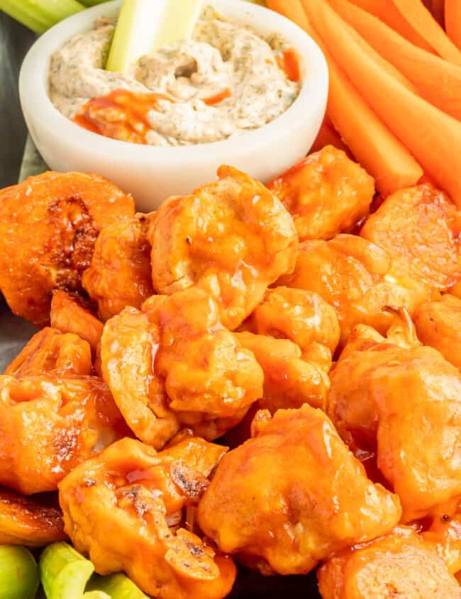 buffalo cauliflower wings on a serving tray with buffalo ranch dressing in a white bowl