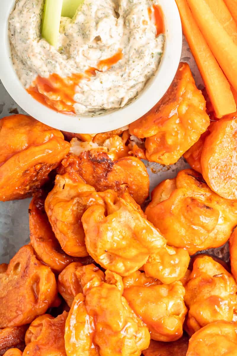 buffalo cauliflower wings on a serving tray with buffalo ranch dressing in a white bowl
