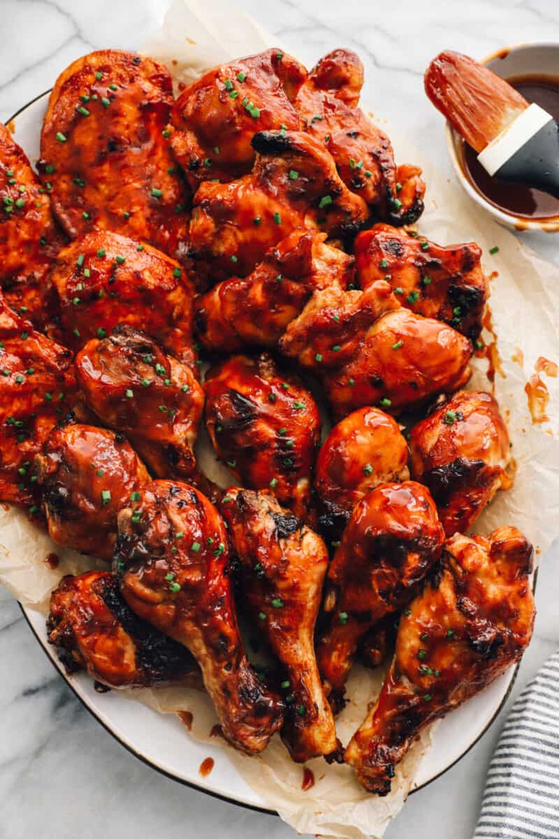 baked bbq chicken breasts, thighs, and drumsticks on a serving platter