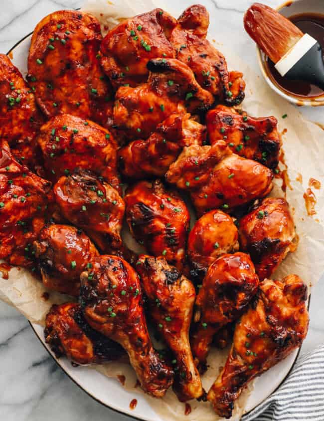 baked bbq chicken breasts, thighs, and drumsticks on a serving platter