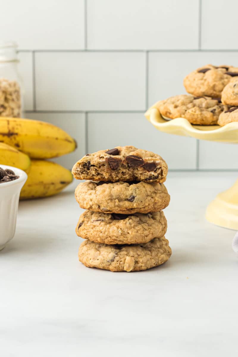 stack of 4 banana oatmeal cookies with a bite taken from the top cookie.