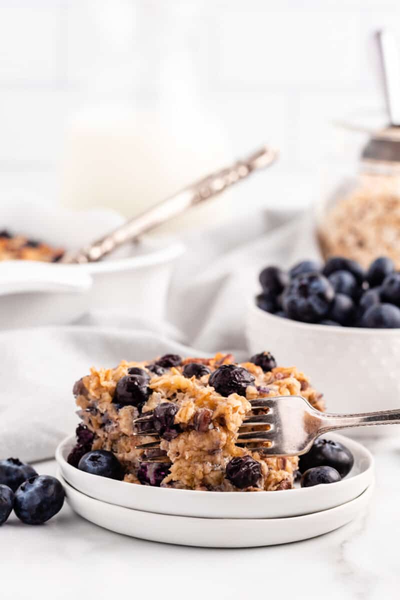 fork with a piece of blueberry baked oatmeal on a white plate