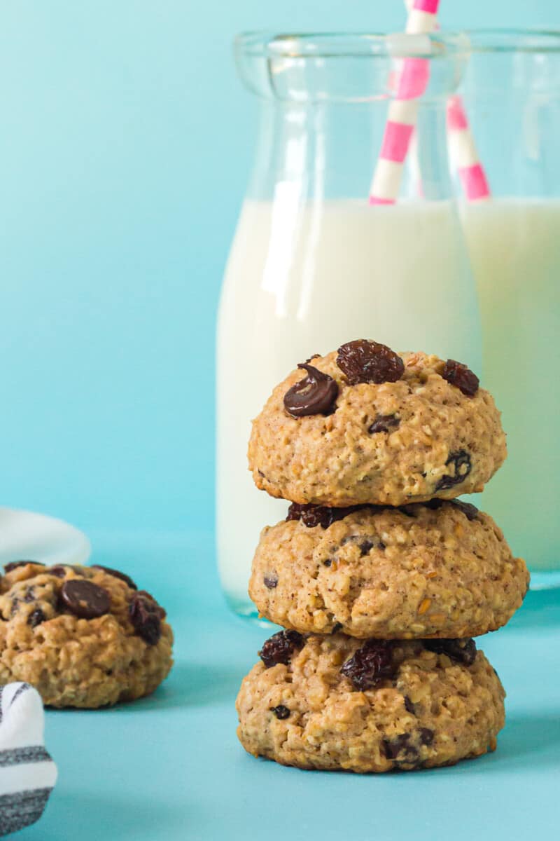 stack of 3 chocolate chip breakfast cookies with a glass of milk with a straw