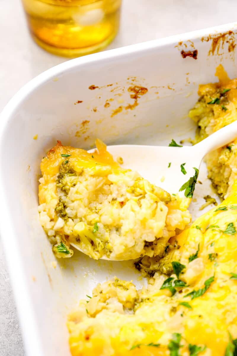 serving spoon in a baking dish filled with broccoli rice casserole