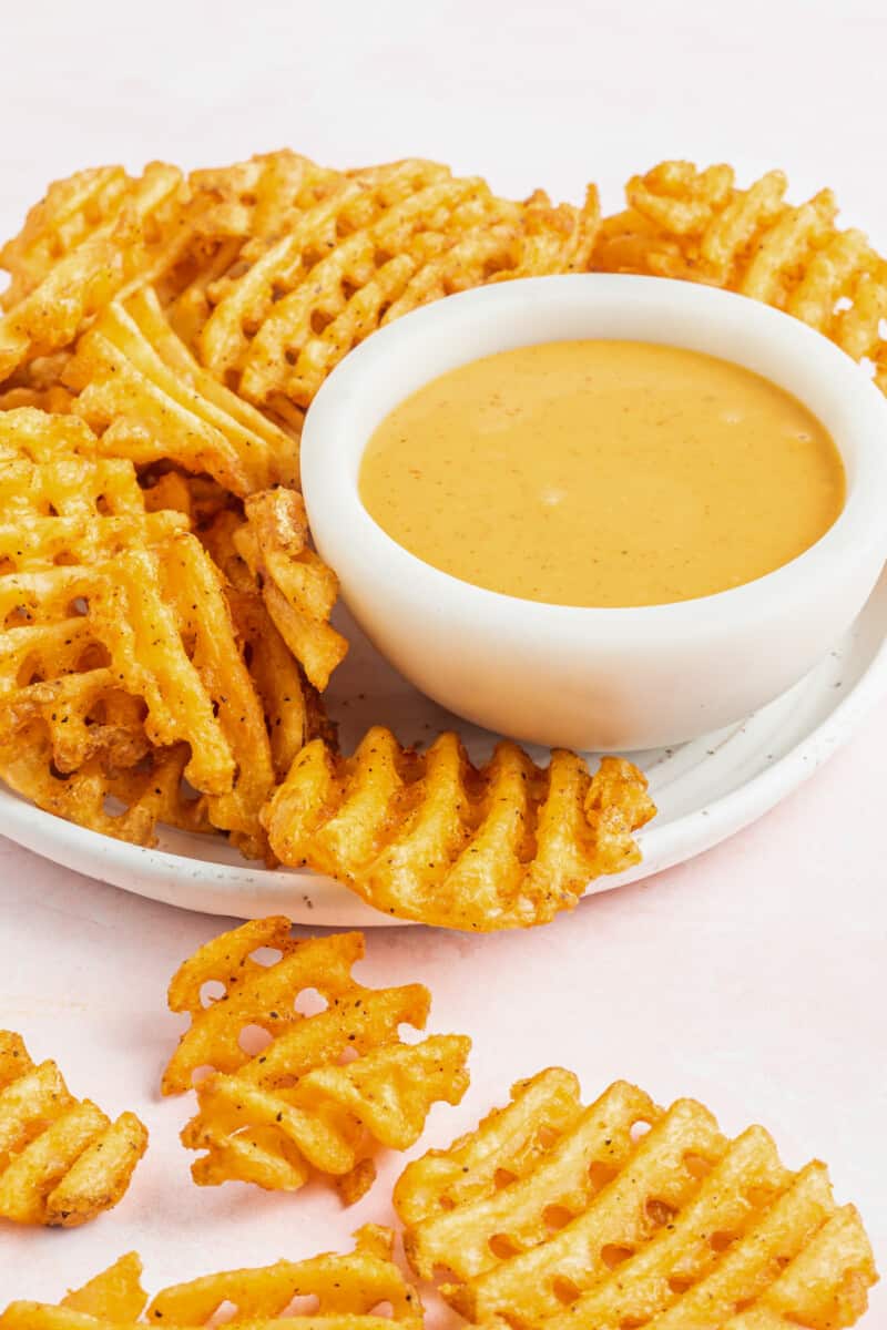 chick-fil-a sauce in a white bowl on a serving platter with waffle fries