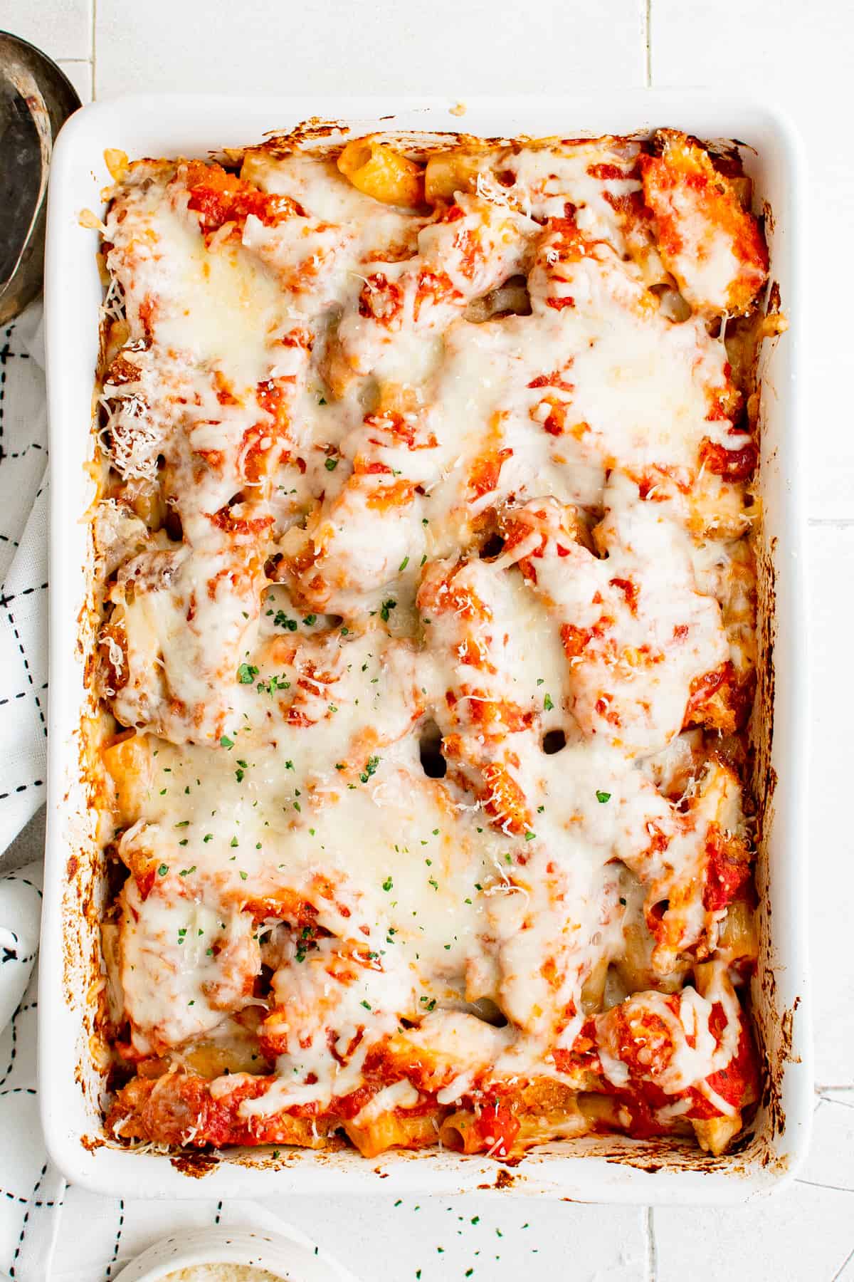 overhead image of chicken parmesan casserole in a white baking dish