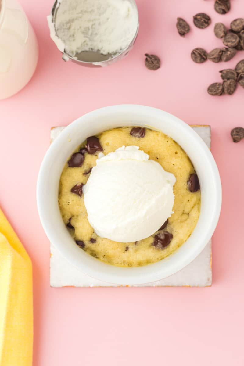 chocolate chip cookie in a mug topped with a scoop of vanilla ice cream