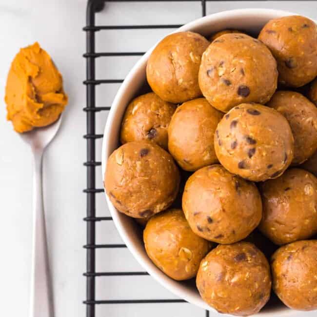 overhead image of chocolate peanut butter protein balls in a white bowl