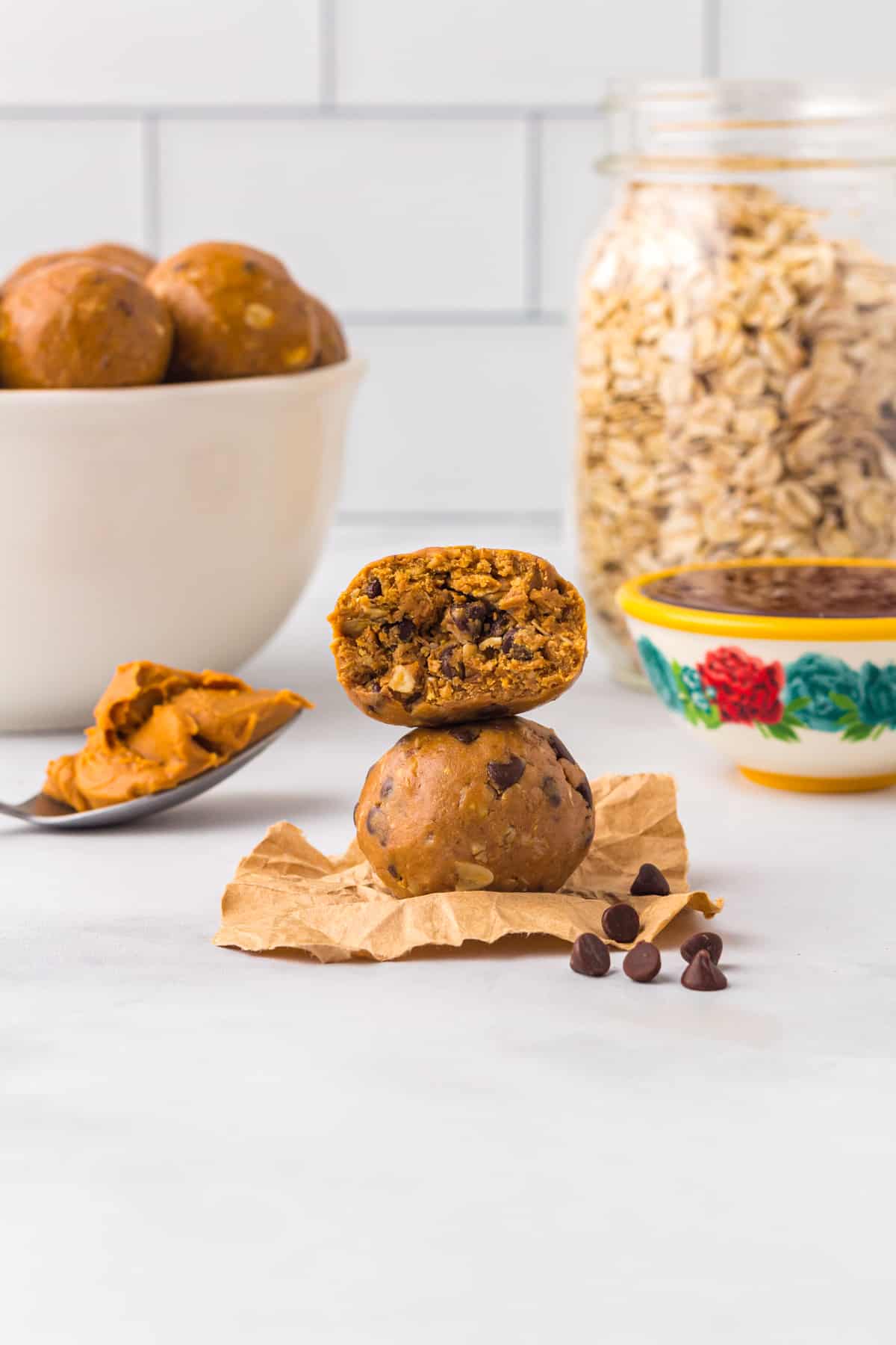 Stack of two chocolate peanut butter protein balls with a bite taken from the top one.