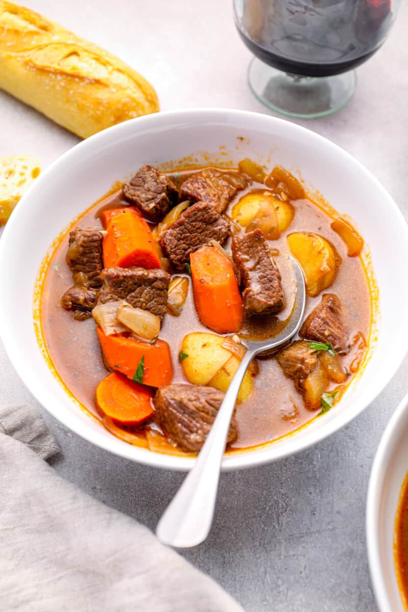 beef stew in a white bowl with a spoon