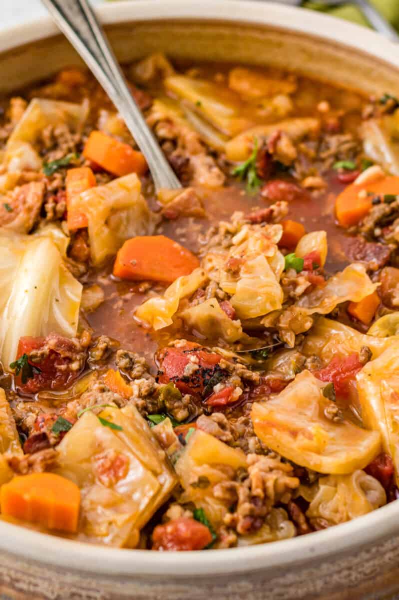 cabbage roll soup in a white bowl with a spoon