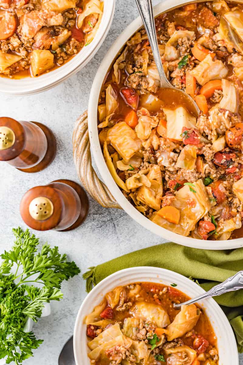 overhead image of cabbage roll soup in a white bowls with spoons